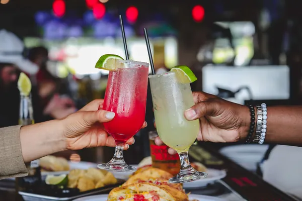 Friends raising cocktails at the bar